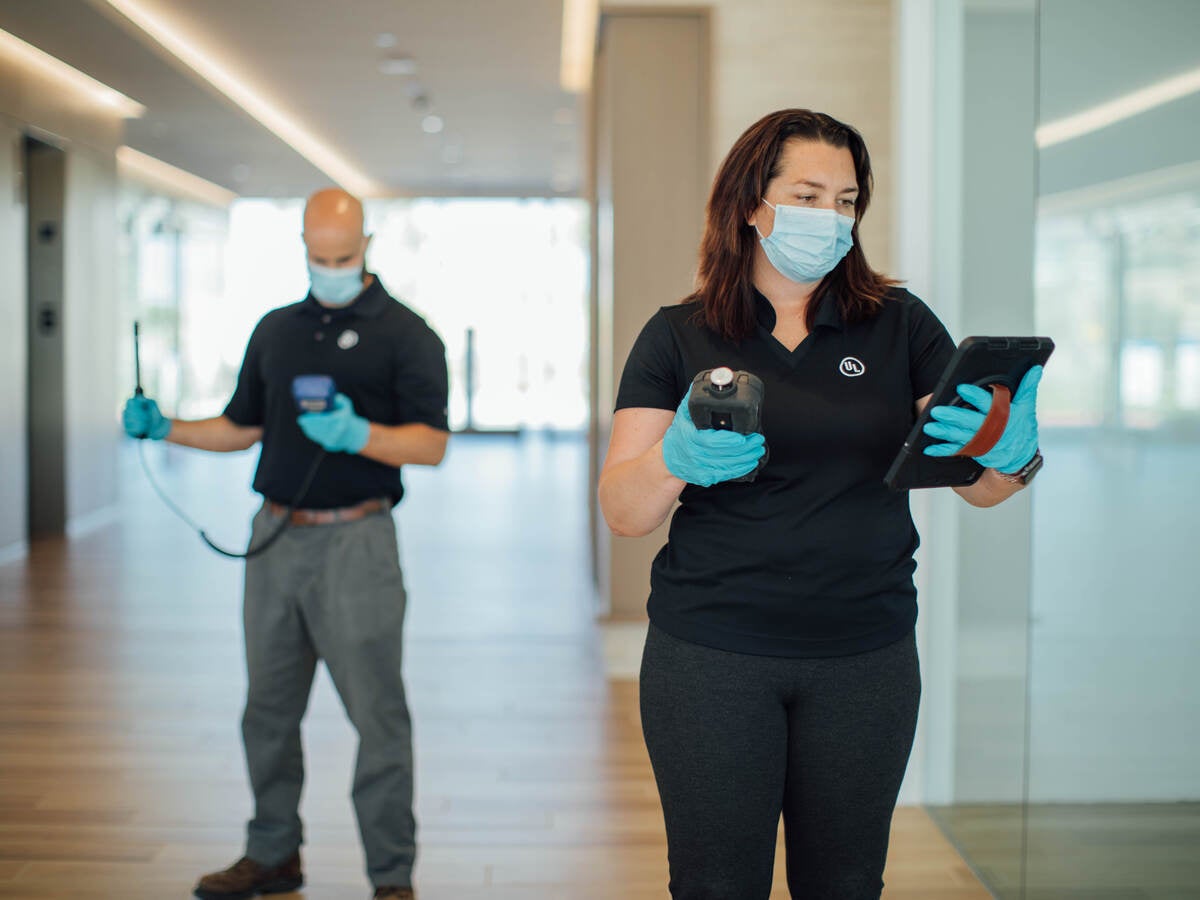 Two UL insprectors in masks conducting indoor air quality testing